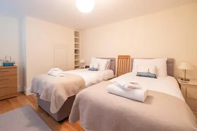 a bedroom with two beds with towels on them at Polly's - Aldeburgh Coastal Cottages in Aldeburgh