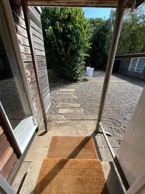 an open glass door of a house with a door at Wood Place in Diss