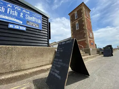 a sign in front of a building with a clock tower at Wood Place in Diss