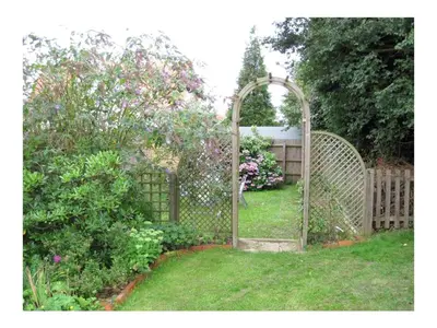 an open gate in a yard with a garden at Beaver Cottage in Aldeburgh