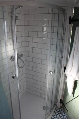 a shower with a glass door in a bathroom at Waterbeach Boatel in Cambridge