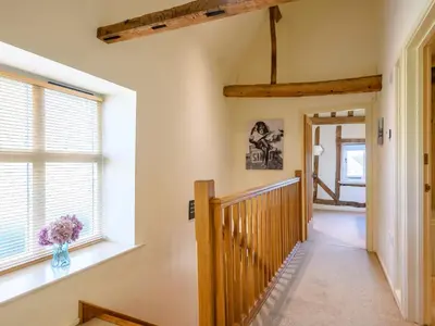 a hallway with a window and a vase of flowers at Laurel Barn in Ashwellthorpe