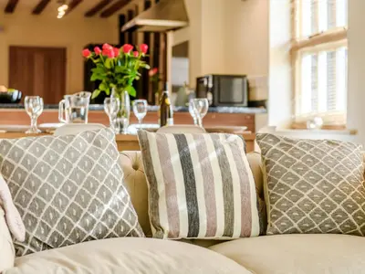 a living room with a couch and a table with wine glasses at Laurel Barn in Ashwellthorpe