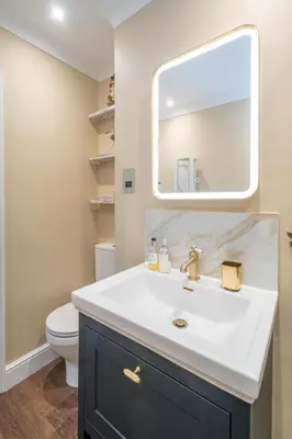 a bathroom with a white sink and a mirror at 69 Saxmundham Road in Aldeburgh