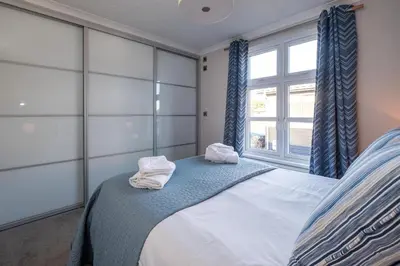 a bedroom with a bed with towels on it at Sea Breeze - Aldeburgh Coastal Cottages in Sizewell