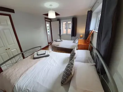 a bedroom with two beds with white sheets at Low Farm Cottages in Woodbridge