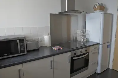 a kitchen with a microwave oven and a refrigerator at Toothbrush Apartments - Ipswich Waterfront South - Avalon Court in Ipswich