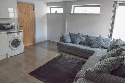 a living room with a couch and a washing machine at Toothbrush Apartments - Central Ipswich - Fore St in Ipswich