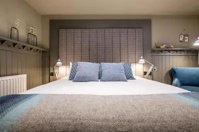 a bedroom with a large white bed with blue pillows at The Three Blackbirds in Stetchworth
