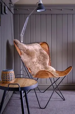 a furry chair and a table in a room at The Three Blackbirds in Stetchworth