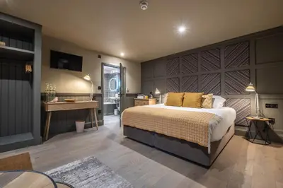 a bedroom with a large bed and a desk at The Three Blackbirds in Stetchworth