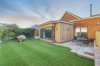 a backyard with a wooden house and a lawn at 2 Bed in Snape oc-sfvin in Snape