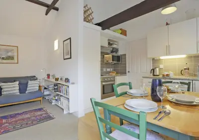 a kitchen and a dining room with a table and chairs at High Tide in Aldeburgh