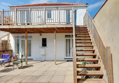 a house under construction with a deck and stairs at High Tide in Aldeburgh