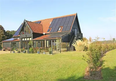 a large house with solar panels on top of it at 1 Bed in Woodbridge oc-meb in Sudbourne