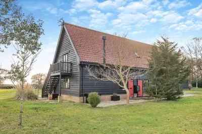 a large house with a gambrel roof and a balcony at 1 Bed in Woodbridge oc-meb in Sudbourne
