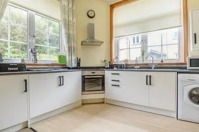 a kitchen with white cabinets and a washer and dryer at 1 Bed in Sizewell oc-gdnf in Sizewell
