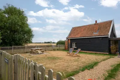 a backyard with a wooden fence and a house at 1 Bed in Ipswich oc-spha in Harkstead