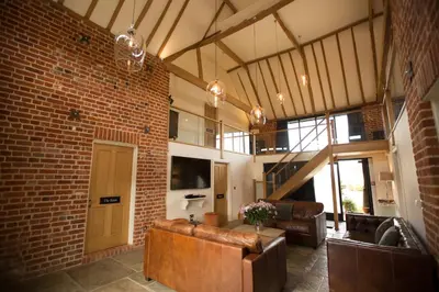 a living room with a couch and a brick wall at Channels Retreat in Chelmsford