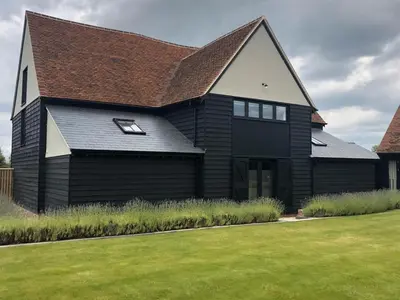 a black house with a brown roof at Channels Retreat in Chelmsford