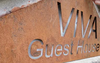 a sign for a guest house on the side of a building at Viva Guest House in Clacton-on-Sea