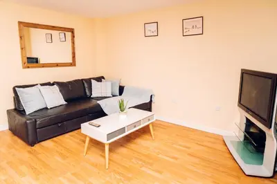 a living room with a black leather couch and a tv at Comfortable Colchester Home in Colchester