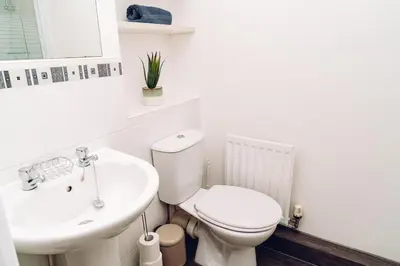 a white bathroom with a toilet and a sink at Comfortable Colchester Home in Colchester
