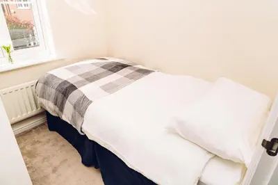 a bedroom with a bed with a checkered blanket at Comfortable Colchester Home in Colchester