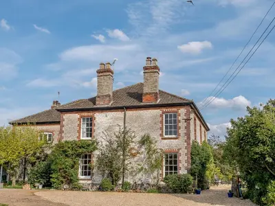 an old brick house with two chimneys on top of it at Colveston Manor in Cranwich
