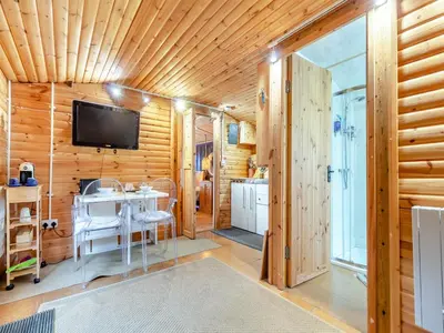 a room with a table and a tv on a wooden wall at Easthorpe Retreat in Copford