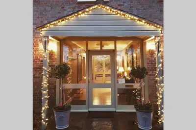 an entrance to a house with lights and a door at The Coach House at Lodge Farm with Hot Tub in Hilgay
