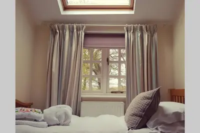 a bedroom with a bed and a window at The Coach House at Lodge Farm with Hot Tub in Hilgay