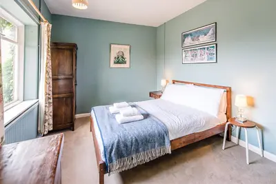 a bedroom with a bed with a blue wall at The Shealing, Waldringfield in Waldringfield
