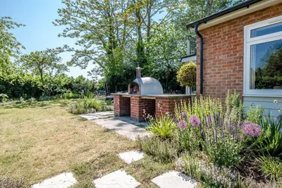 a garden with a brick fireplace next to a house at The Shealing, Waldringfield in Waldringfield