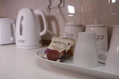 a plate of food on a counter next to cups at Peaceful 3 Bed Home in Basildon