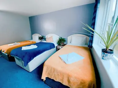 two beds sitting next to each other in a room at Redwings Lodge Baldock in Baldock