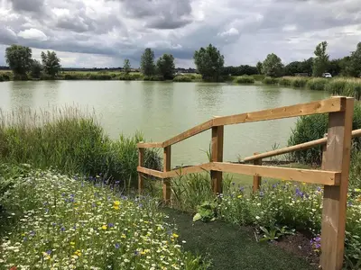 a wooden fence in front of a river with flowers at Deer Lodge - Ukc4325 in Pidley