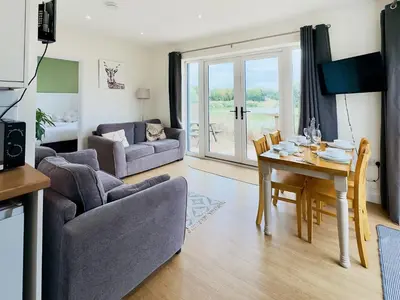 a living room with a table and a dining room at Hare Lodge - Uk30604 in Pidley
