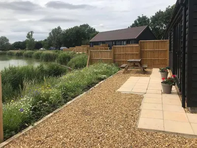 a garden with a picnic table next to a pond at Hare Lodge - Uk30604 in Pidley