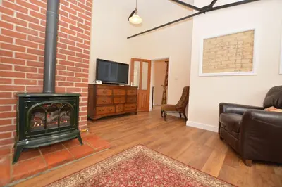 a living room with a brick wall and a fireplace at wingate cottage in Southburgh
