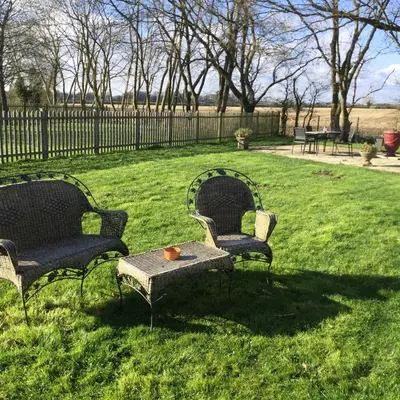 two chairs and a table in the grass at wingate cottage in Southburgh