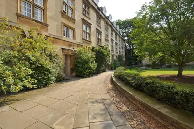 an empty sidewalk in front of a building at Christ's College Cambridge in Cambridge