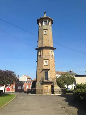 a tall brick tower with a fence around it at The Bakehouse in Harwich