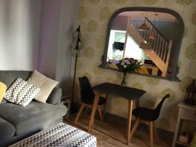 a living room with a couch and a table with a mirror at The Bakehouse in Harwich