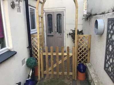 a wooden gate leading into a house with a door at The Bakehouse in Harwich