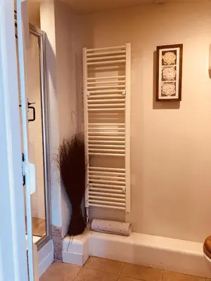 a bathroom with a shower with a shutter on the wall at The Blue Cow in Fenstanton