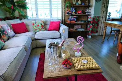 a living room with a couch and a coffee table at Lakeland Lodge with private Hot Tub and fishing in Hatfield Peverel