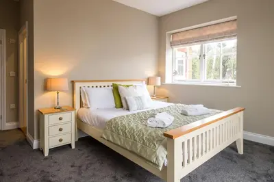 a bedroom with a bed with two lamps and a window at The Dower House in Sizewell