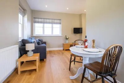 a living room with a table and a couch at The Dower Retreat in Sizewell