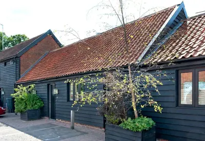 a blue house with a tree in front of it at The Fox by Greene King Inns in Bury Saint Edmunds